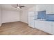 Kitchenette with white cabinets, sink, refrigerator, and laminate flooring at 7985 Thunder River Way, Cumming, GA 30028
