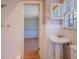 Bathroom with white tile, a window, pedestal sink, and doorway to an adjacent room at 2609 Colonial Dr, Atlanta, GA 30337