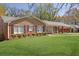 Classic brick house featuring black shutters, manicured shrubbery and green lawn at 2609 Colonial Dr, Atlanta, GA 30337