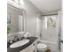 Bathroom with a black countertop, ornate white cabinets, silver framed mirror, and shower/tub combo at 4076 Shady Nw Cir, Lilburn, GA 30047