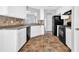 Well-lit kitchen features white cabinetry, black appliances, and tile backsplash at 5016 Larkspur Ln, Atlanta, GA 30349
