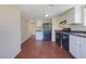 Cozy kitchen with dark wood flooring, black appliances, and white cabinets at 1124 Brandon Hill Way, Jonesboro, GA 30238