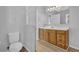 Bright bathroom featuring a wood vanity, tile floors, and a commode at 2551 Tolliver Dr, Ellenwood, GA 30294