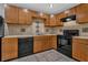 Kitchen with wood cabinets, black appliances, and tiled countertops and backsplash at 2551 Tolliver Dr, Ellenwood, GA 30294