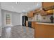 Spacious kitchen with wood cabinets, black appliances, tile floors, and access to outdoor deck at 2551 Tolliver Dr, Ellenwood, GA 30294