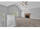 Open living room featuring vaulted ceilings, a cozy fireplace, neutral paint, and soft carpeting at 2551 Tolliver Dr, Ellenwood, GA 30294