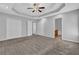 Large bedroom with neutral carpet, tray ceilings, ceiling fan, and multiple closets at 2551 Tolliver Dr, Ellenwood, GA 30294