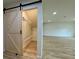 Walk-in closet with a sliding barn door entry, shelving, and bench, in an open-concept living space at 3836 Saddle Hill Way, Douglasville, GA 30135