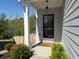 Charming home front entrance featuring a modern black door, manicured landscaping, and a welcoming porch at 3836 Saddle Hill Way, Douglasville, GA 30135