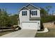 Charming two-story home featuring a two-car garage, gray siding, and manicured landscaping at 3836 Saddle Hill Way, Douglasville, GA 30135