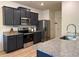 Modern kitchen featuring stainless steel appliances, granite countertops, and dark cabinets at 3836 Saddle Hill Way, Douglasville, GA 30135
