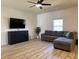 Cozy living room with wood floors, a ceiling fan, and a comfortable gray sofa at 3836 Saddle Hill Way, Douglasville, GA 30135