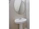 Pedestal sink with an oval mirror in a half bathroom at 5027 Lower Elm St, Atlanta, GA 30349