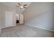 Spacious bedroom featuring plush carpeting, neutral walls, ceiling fan, and ensuite bathroom access at 5027 Lower Elm St, Atlanta, GA 30349