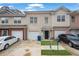 Townhome with a black front door, attached garage, and a well-manicured lawn at 5027 Lower Elm St, Atlanta, GA 30349