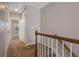 Upstairs hallway with neutral carpet and paint and a wood banister at 5027 Lower Elm St, Atlanta, GA 30349