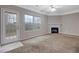 Carpeted living room with a fireplace, a door to the back patio, and windows at 5027 Lower Elm St, Atlanta, GA 30349