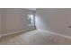 A bright bedroom with neutral walls and carpet, and a window providing natural light at 5414 Splendida Ct, Fairburn, GA 30213