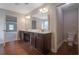 Main bathroom with double vanity, wood floors, and entrances to the toilet and main bedroom at 5414 Splendida Ct, Fairburn, GA 30213