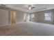 Spacious main bedroom features neutral walls, plush carpet, tray ceiling, and a ceiling fan at 5414 Splendida Ct, Fairburn, GA 30213