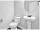 Cozy bathroom features a pedestal sink, toilet, and new laminate flooring at 5456 Union Hill Ct, Union City, GA 30291