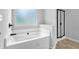 Modern bathroom featuring a luxurious white soaking tub with black hardware and a sleek glass-enclosed shower at 5456 Union Hill Ct, Union City, GA 30291