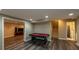 Finished basement with luxury vinyl flooring, a pool table, and access to a bathroom and stairs at 772 Vinings Estates Se Dr, Mableton, GA 30126