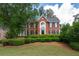 Beautiful two-story brick home featuring manicured landscaping, a symmetrical design and black window shutters at 772 Vinings Estates Se Dr, Mableton, GA 30126