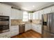 Bright kitchen featuring modern appliances, granite counters, custom backsplash, and ample cabinet space at 772 Vinings Estates Se Dr, Mableton, GA 30126