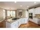 Open-concept kitchen featuring white cabinets, granite countertops, stainless steel appliances and views to the staircase at 772 Vinings Estates Se Dr, Mableton, GA 30126