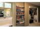 View of main bath with tub, shelves and entrance to walk-in closet at 772 Vinings Estates Se Dr, Mableton, GA 30126