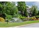 Scenic pond with a fountain, waterfall and lush greenery surrounding a traditional-style home at 772 Vinings Estates Se Dr, Mableton, GA 30126