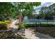 Community tennis courts with well-maintained fencing and a small building in a lushly landscaped area at 772 Vinings Estates Se Dr, Mableton, GA 30126