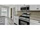 Close-up of kitchen with stainless steel appliances, granite countertops, and white cabinets at 1335 Jamestowne Trl, Alpharetta, GA 30009