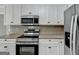 Close-up of kitchen with stainless steel appliances and white cabinets at 1335 Jamestowne Trl, Alpharetta, GA 30009