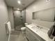 Bathroom with a glass door shower and modern single sink vanity with quartz countertops at 1888 Peeler Rd, Dunwoody, GA 30338