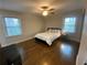 Bedroom with hardwood floors, a ceiling fan, a queen size bed, and two windows at 1888 Peeler Rd, Dunwoody, GA 30338