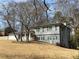 Split-level home with gray brick and vinyl siding and windows with black shutters at 1888 Peeler Rd, Dunwoody, GA 30338