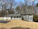 Split-level home with gray siding, a well-kept lawn, and a mix of shade trees at 1888 Peeler Rd, Dunwoody, GA 30338