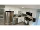 Well-equipped kitchen featuring white cabinets, stainless steel appliances, and ample counter space at 1888 Peeler Rd, Dunwoody, GA 30338