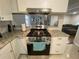 Modern kitchen stove featuring stainless steel appliances, granite countertops, and white cabinets at 1888 Peeler Rd, Dunwoody, GA 30338