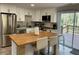 Modern kitchen featuring white cabinets, stainless steel appliances, and a center island with seating at 1888 Peeler Rd, Dunwoody, GA 30338