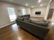 Living room with hardwood floors, neutral walls, and a large gray sofa at 1888 Peeler Rd, Dunwoody, GA 30338