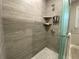 Modern shower with tile surround, dual shelves, and glass enclosure at 1888 Peeler Rd, Dunwoody, GA 30338