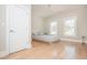 Minimalist bedroom featuring hardwood floors, two windows providing natural light, and a comfy bed at 5915 Brookgreen Rd, Atlanta, GA 30328