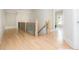 Bright hallway featuring hardwood floors, modern railings and natural light streaming through the nearby windows at 5915 Brookgreen Rd, Atlanta, GA 30328