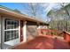Exterior view of a brick house with a wood deck with red railings and door and screen at 1025 Pace Rd, Hiram, GA 30141