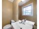 A well-lit bathroom with a sink, a toilet, a window, and neutral-colored walls at 1025 Pace Rd, Hiram, GA 30141