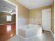 Well-lit bathroom featuring a corner tub with tile surround, door and neutral walls at 1025 Pace Rd, Hiram, GA 30141