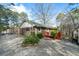 Charming brick home with a red wood deck nestled among mature trees at 1025 Pace Rd, Hiram, GA 30141
